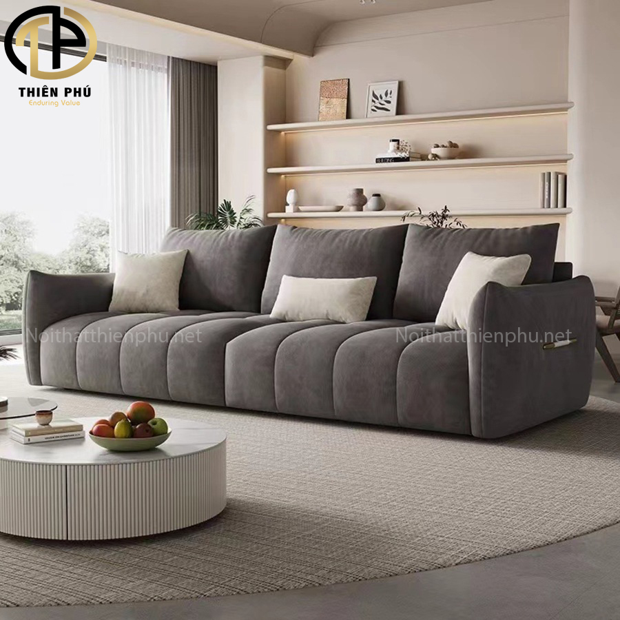 Chiếc ghế sofa dài màu xám nhạt có kiểu dáng hiện đại và chân kim loại phù hợp với phòng khách rộng.